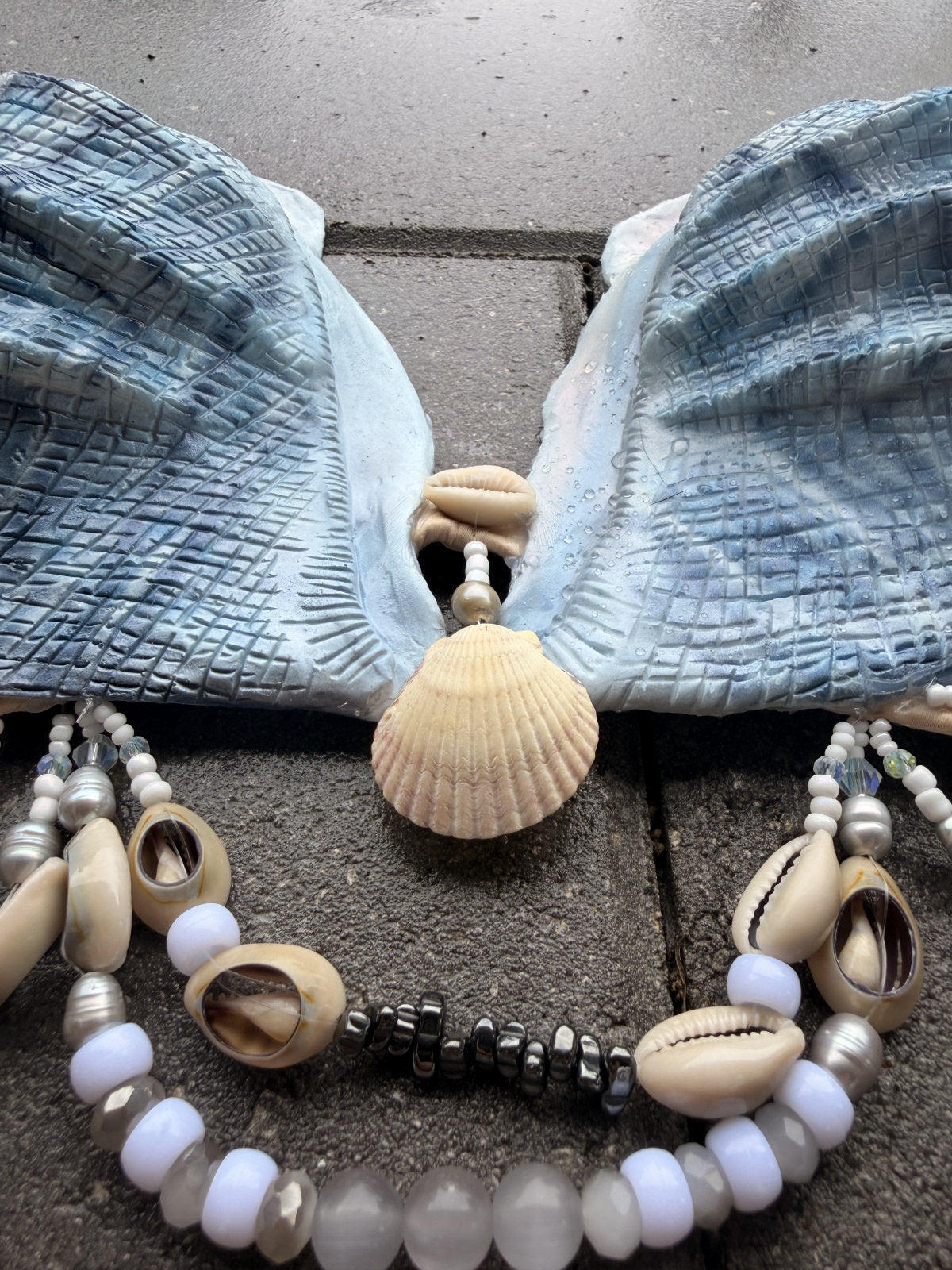 Close-up of center shell and decorative beadwork between the cups of the Blue Siren silicone mermaid top